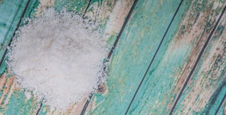 Dried coconut powder over wooden background