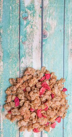Breakfast cereal with dried raspberry fruit pieces over wooden backgroundの写真素材