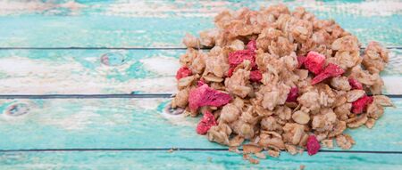 Breakfast cereal with dried raspberry fruit pieces over wooden backgroundの写真素材