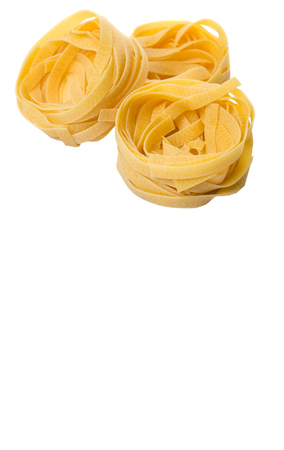 Dried tagliatelle pasta or ribbon shaped pasta or nest shape pasta over white backgroundの写真素材