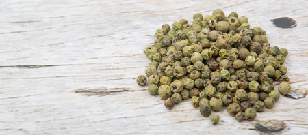Dried green peppercorn wooden backgroundの写真素材