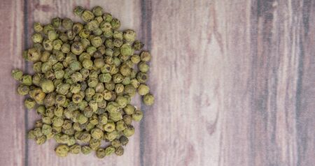 Dried green peppercorn wooden backgroundの写真素材