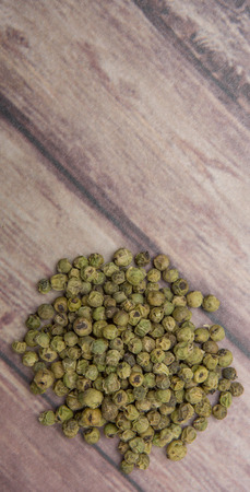 Dried green peppercorn wooden backgroundの写真素材