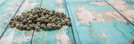 Dried green peppercorn wooden backgroundの写真素材
