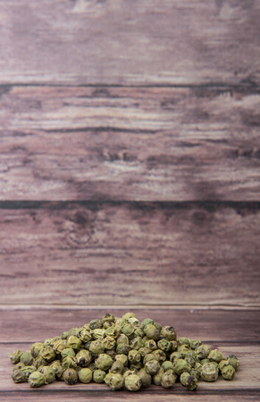 Dried green peppercorn wooden backgroundの写真素材