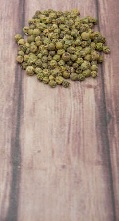 Dried green peppercorn wooden background