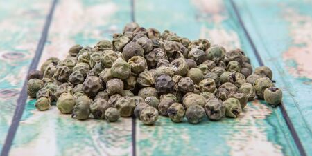 Dried green peppercorn wooden backgroundの写真素材