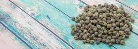 Dried green peppercorn wooden backgroundの写真素材