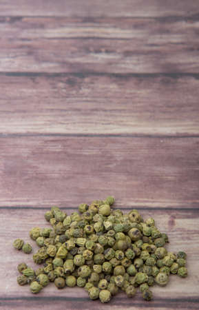 Dried green peppercorn wooden backgroundの写真素材