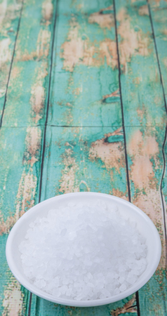 Sea salt in wooden bowl over wooden backgroundの写真素材