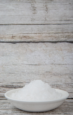 Sea salt in wooden bowl over wooden backgroundの写真素材