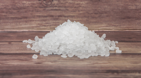 Sea salt over wooden background
