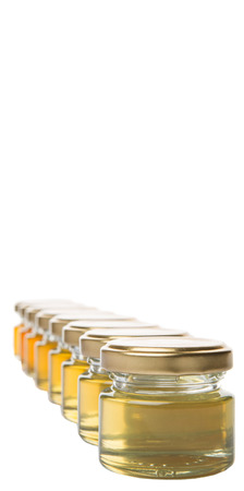 Different grade and color of honey in mason jar over white backgroundの写真素材