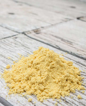 Ground mustard powder over wooden backgroundの写真素材