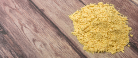 Ground mustard powder over wooden backgroundの写真素材