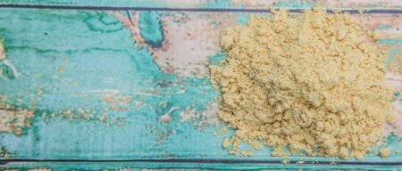 Ground mustard powder over wooden backgroundの写真素材