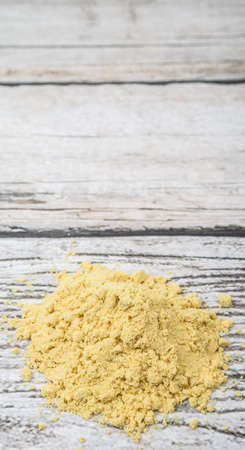 Ground mustard powder over wooden backgroundの写真素材