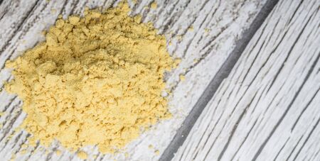 Ground mustard powder over wooden backgroundの写真素材