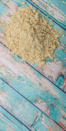 Ground mustard powder over wooden backgroundの写真素材