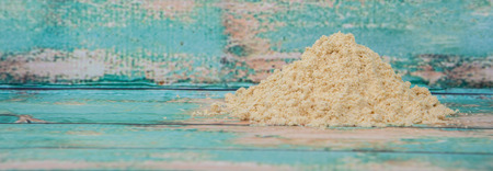 Ground mustard powder over wooden backgroundの写真素材