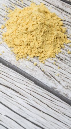 Ground mustard powder over wooden backgroundの写真素材