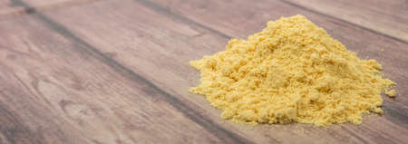 Ground mustard powder over wooden background