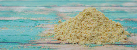 Ground mustard powder over wooden backgroundの写真素材