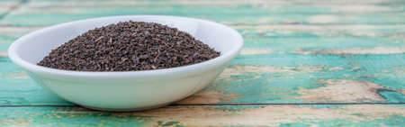 Black Ceylon tea in white bowl over wooden backgroundの写真素材