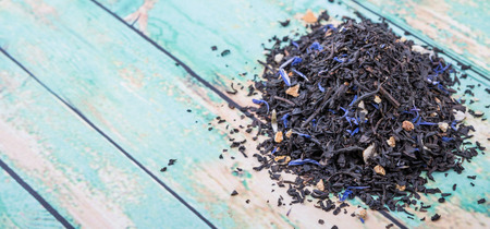Dried black Earl Grey tea leaves over wooden backgroundの写真素材