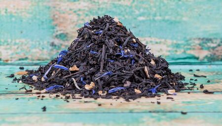 Dried black Earl Grey tea leaves over wooden backgroundの写真素材
