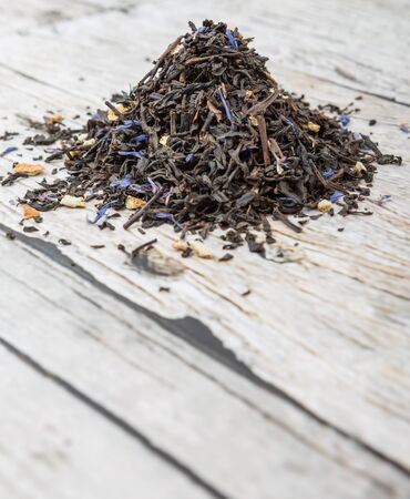 Dried black Earl Grey tea leaves over wooden backgroundの写真素材