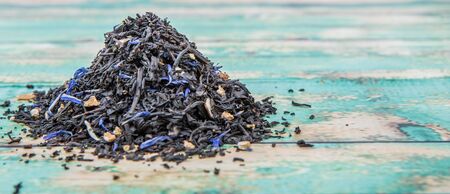 Dried black Earl Grey tea leaves over wooden backgroundの写真素材