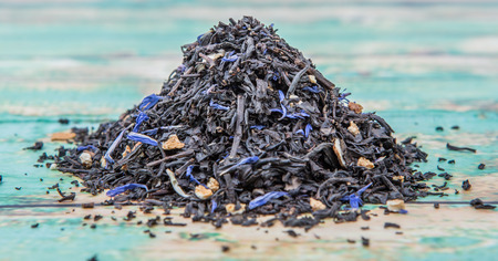 Dried black Earl Grey tea leaves over wooden backgroundの写真素材