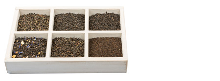 Dried variety of black tea leaves in white square box over wooden backgroundの写真素材