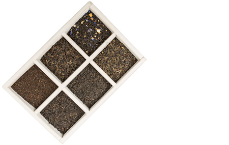 Dried variety of black tea leaves in white square box over wooden backgroundの写真素材