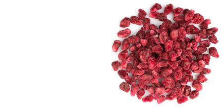 Dried pomegranate seeds in white bowl over wooden background