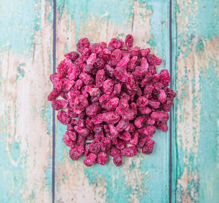 Dried pomegranate seeds over wooden background