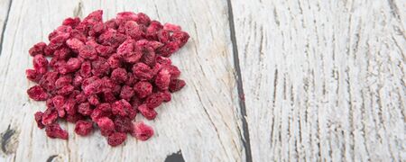 Dried pomegranate seeds over wooden background