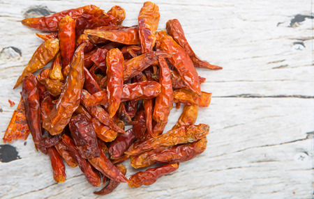 Dried cayenne pepper over wooden background