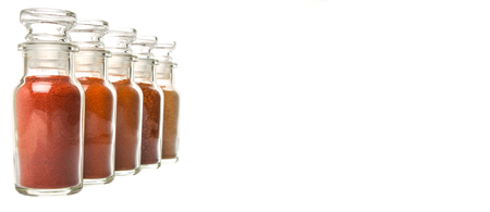 Different type and colors of chilly powder, paprika powder, cayenne powder in glass vial over white backgroundの写真素材