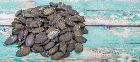 Roasted pumpkin seed over wooden background