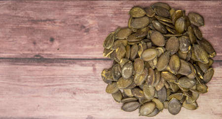 Roasted pumpkin seed over wooden background