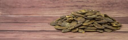 Roasted pumpkin seed over wooden background