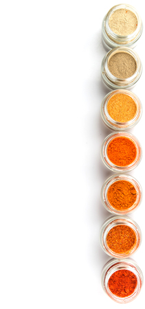 Hot and spicy spices powder, cayenne powder, chilly powder, peppercorn powder, paprika powder, black pepper and white pepper powder in small mason jar over white backgroundの写真素材