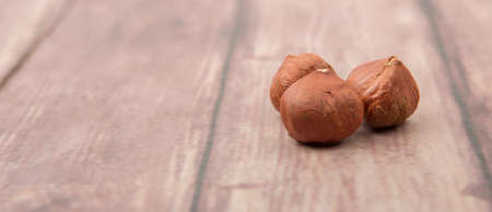 Peeled hazelnut nut over wooden background