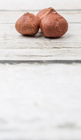Peeled hazelnut nut over wooden background
