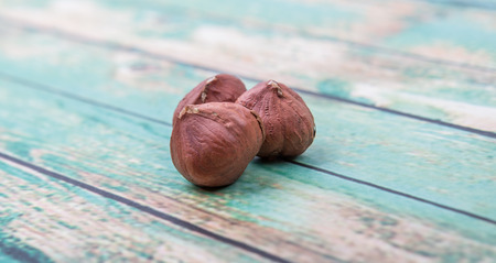 Peeled hazelnut nut over wooden backgroundの写真素材
