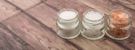 Table salt, sea salt and himalayan salt in mason jar over wooden backgroundの写真素材