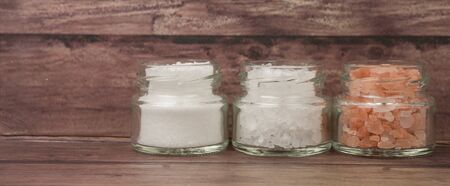 Table salt, sea salt and himalayan salt in mason jar over wooden backgroundの写真素材
