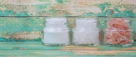 Table salt, sea salt and himalayan salt in mason jar over wooden backgroundの写真素材